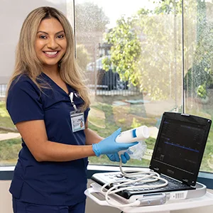 medical professional holding ultrasound probe to ultrasound machine